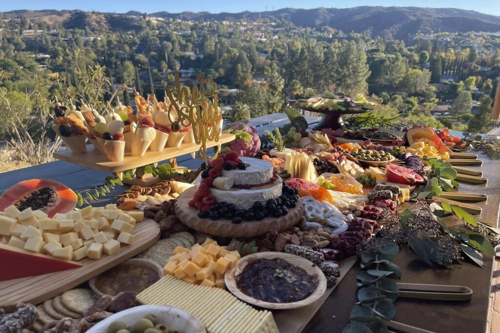 An elaborate spread of food is displayed high above a valley on a rooftop