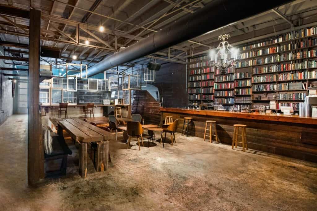 a rustic bar with a bookshelf wall