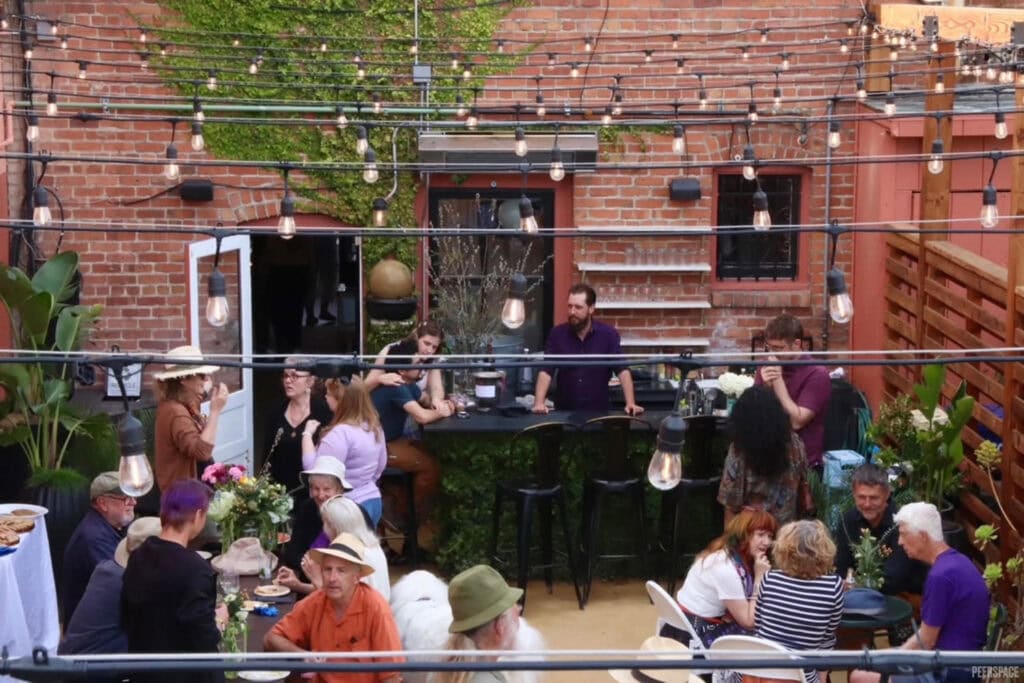 Friends gather on an outdoor patio under bistro lights