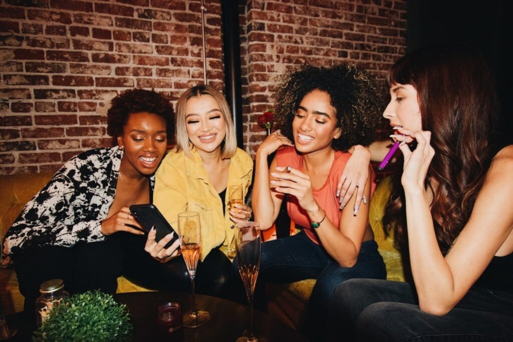 friends with wine looking at a phone