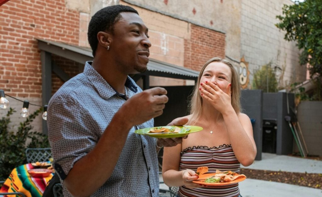 friends laughing and holding plates of mexican food