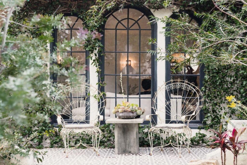 Danity wire chairs sit in an enchanted garden setting