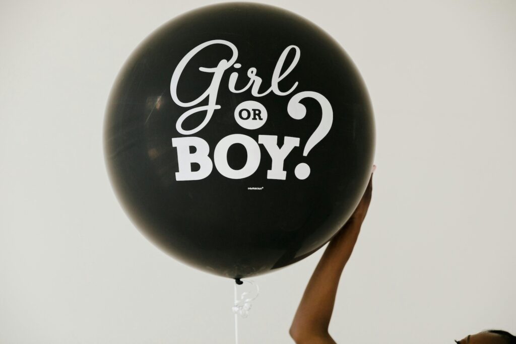 A giant black balloon with the words "Girl or Boy?" on it at a baby event