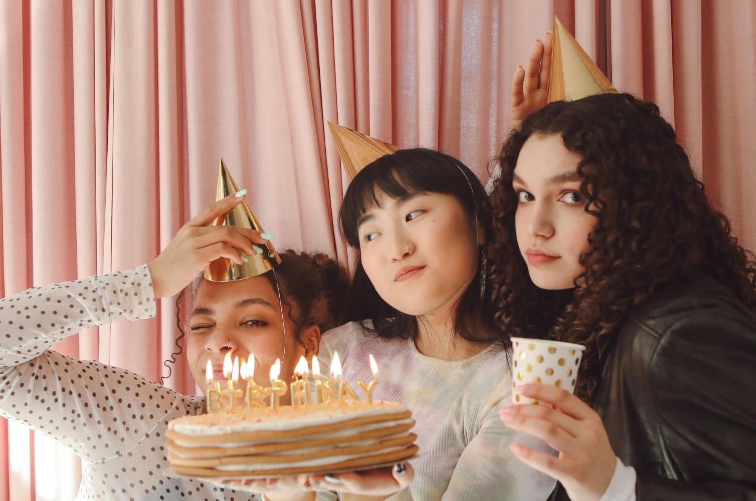girls celebrating a teen birthday with hats and cake