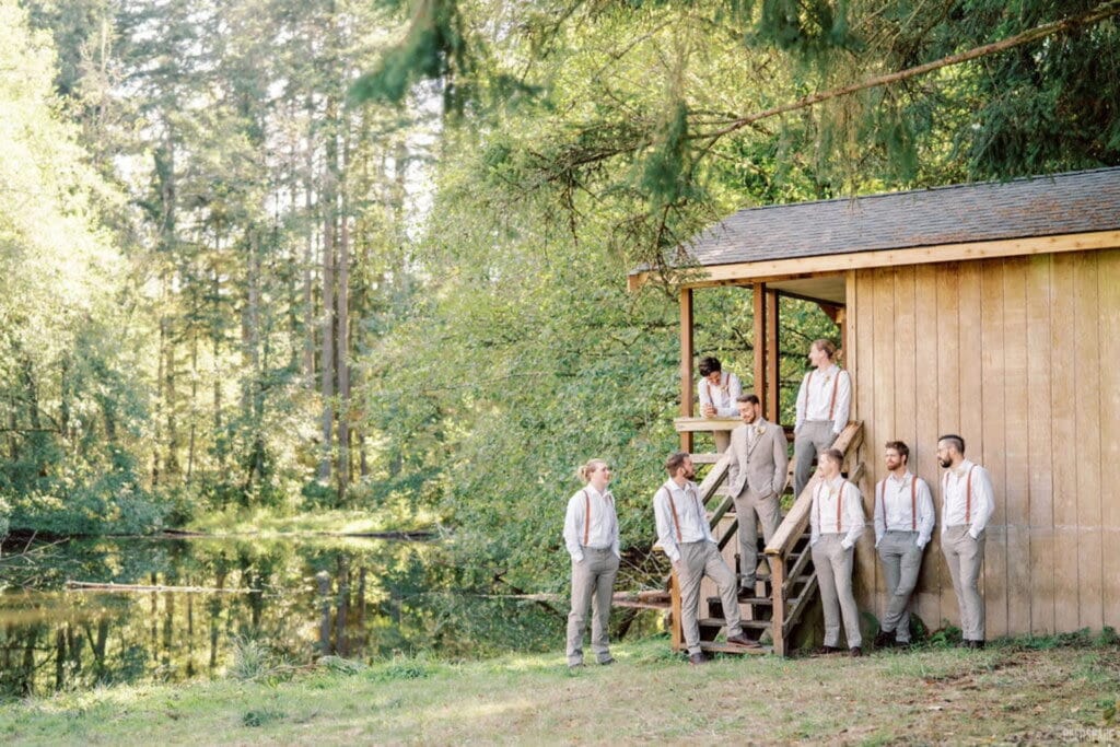 Groomsmen gather at a cabin by a lake