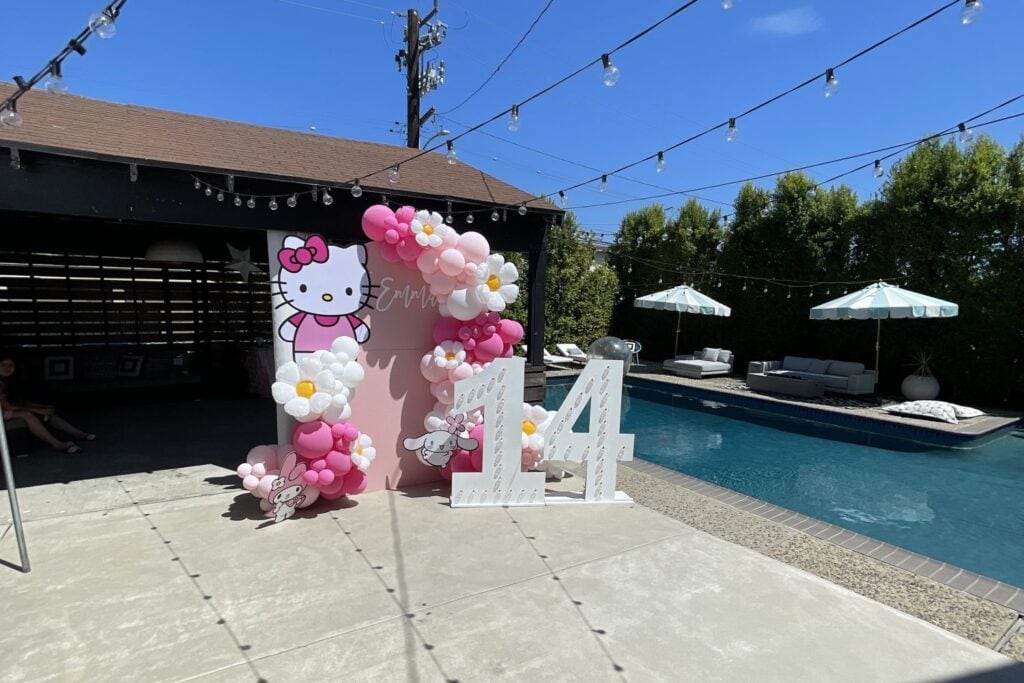 hello kitty 14th birthday decor at a poolside venue
