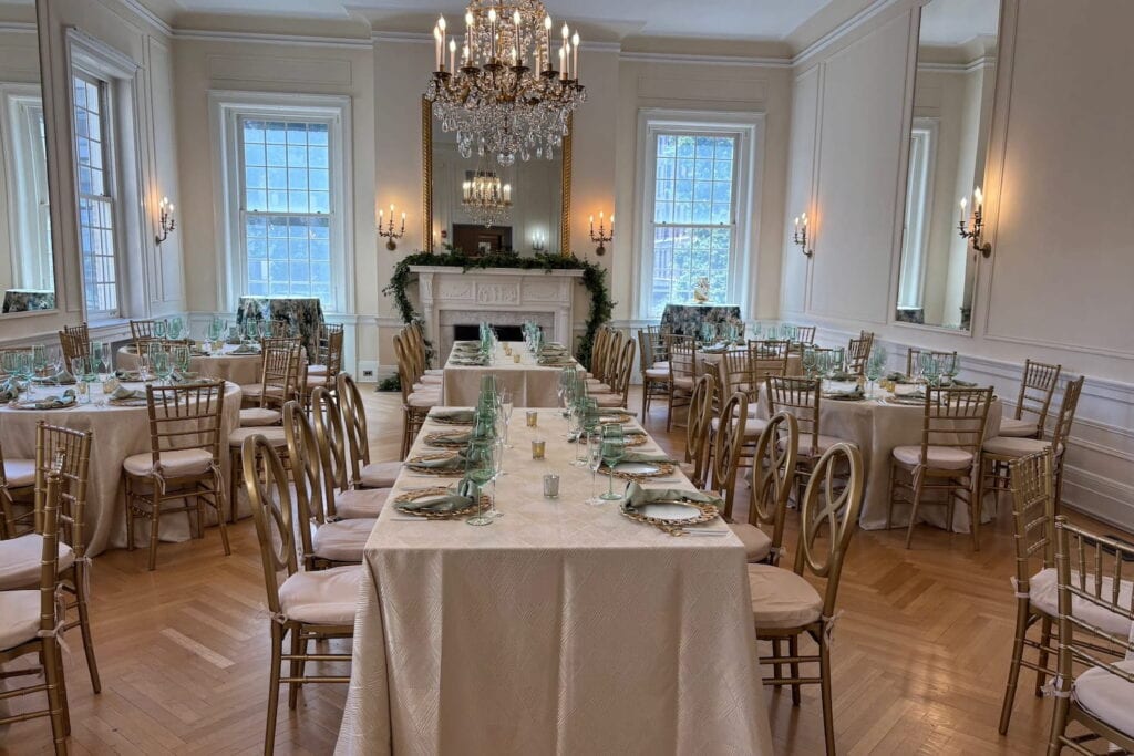 Small reception set up at a historic Dupont Circle home with chandeliers, wood floors, a fireplace and tall windows