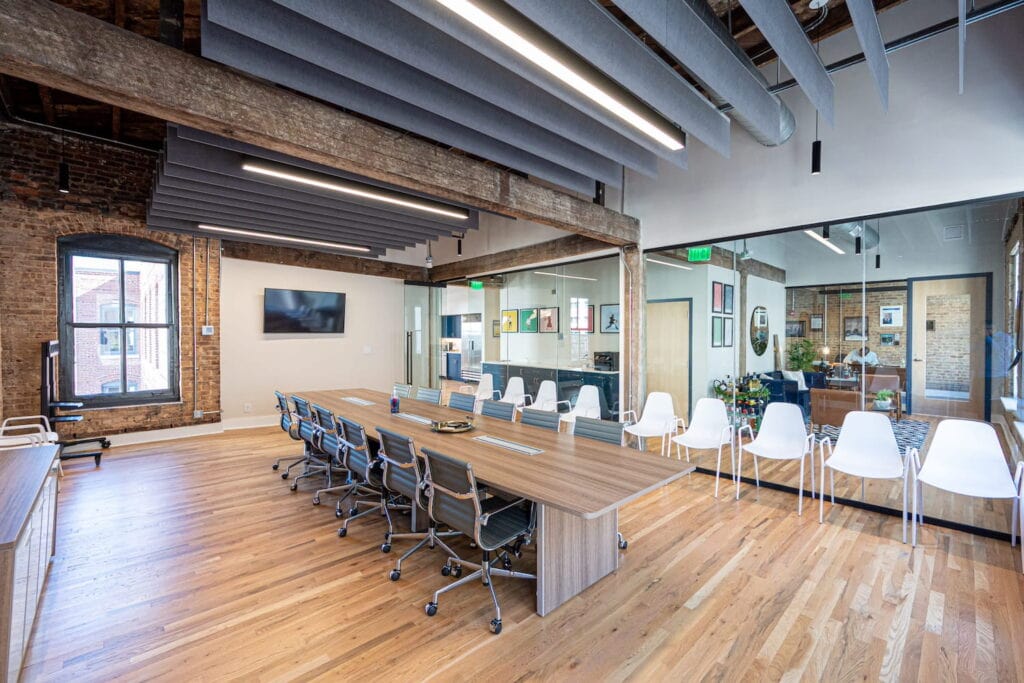 Exposed brick walls, wood beams and large windows create an industrial backdrop for a modern office space in Atlanta