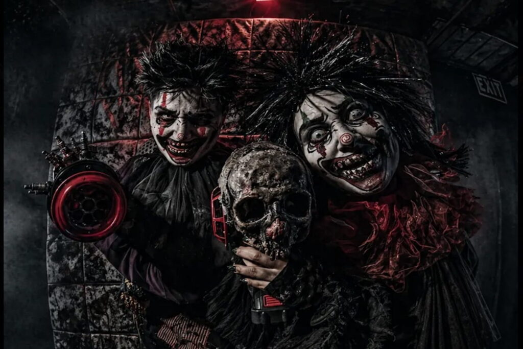People in creepy masks holding skulls at a Halloween scream park