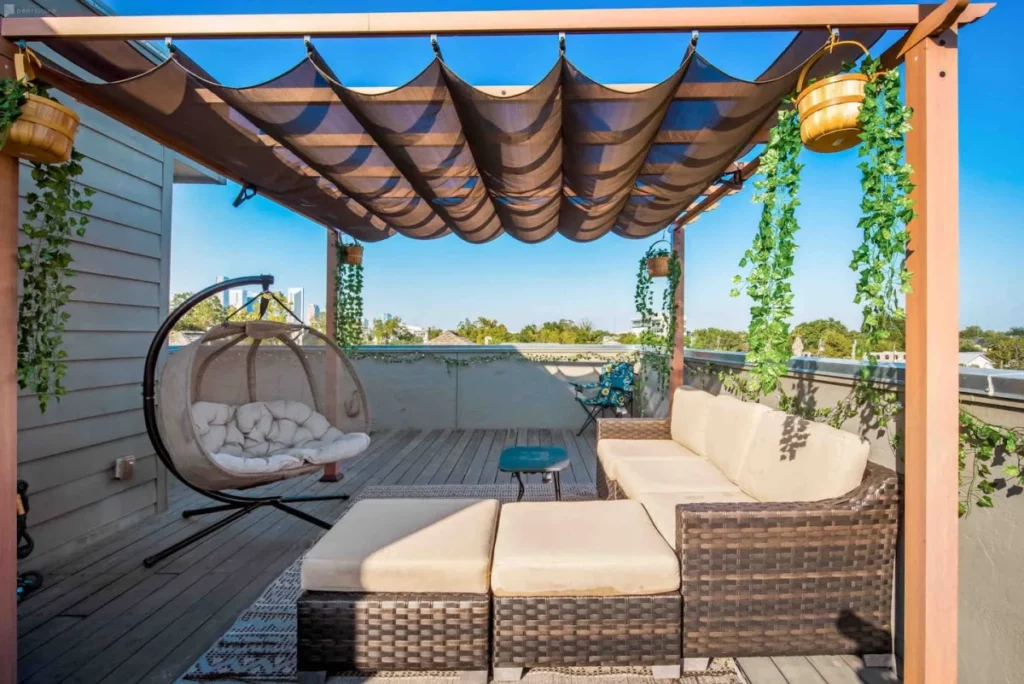 a rooftop deck with covered seating area