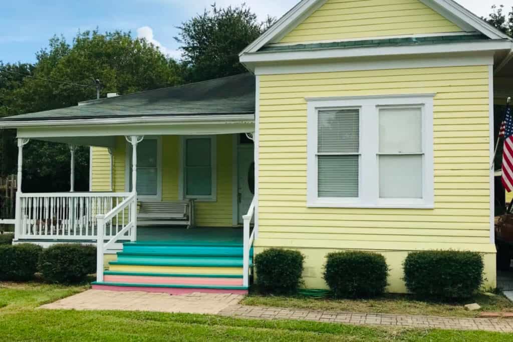 historic yellow home with rainbow porch