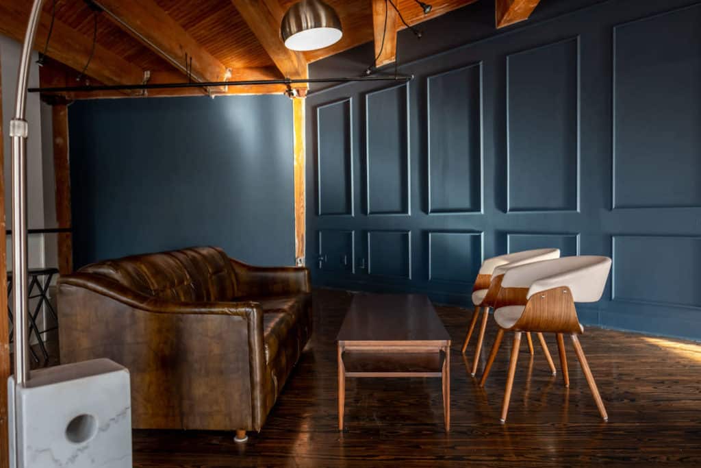 Industrial photo shoot location with dark paneled walls and luxurious leather furniture in Houston, Texas