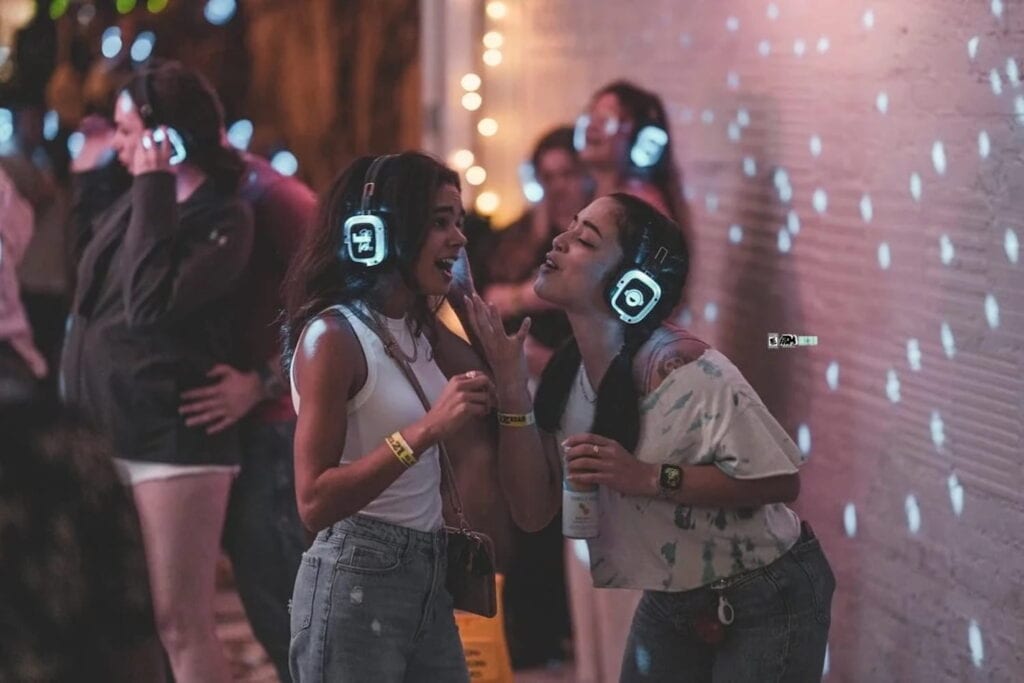 Two women in illuminated headphones participate in a silent disco