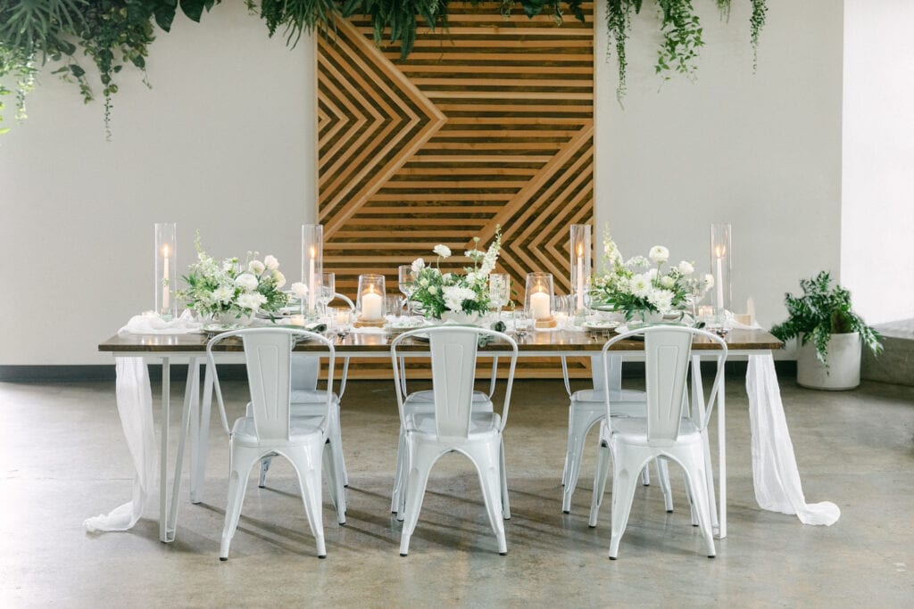 Pristine reception table set up for an intimate gathering in bright, white space