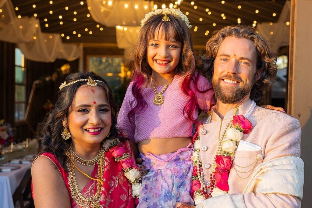 Bride and groom with child dressed in traditional Indian wedding attire