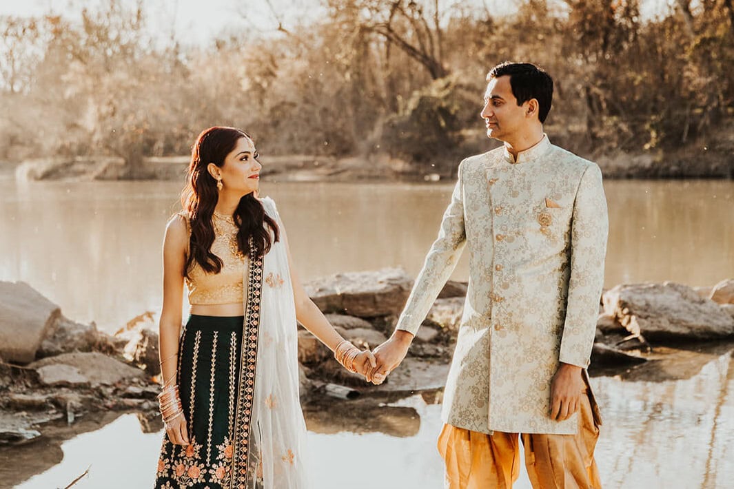 Indian wedding couple holding hands by a river in New Jersey