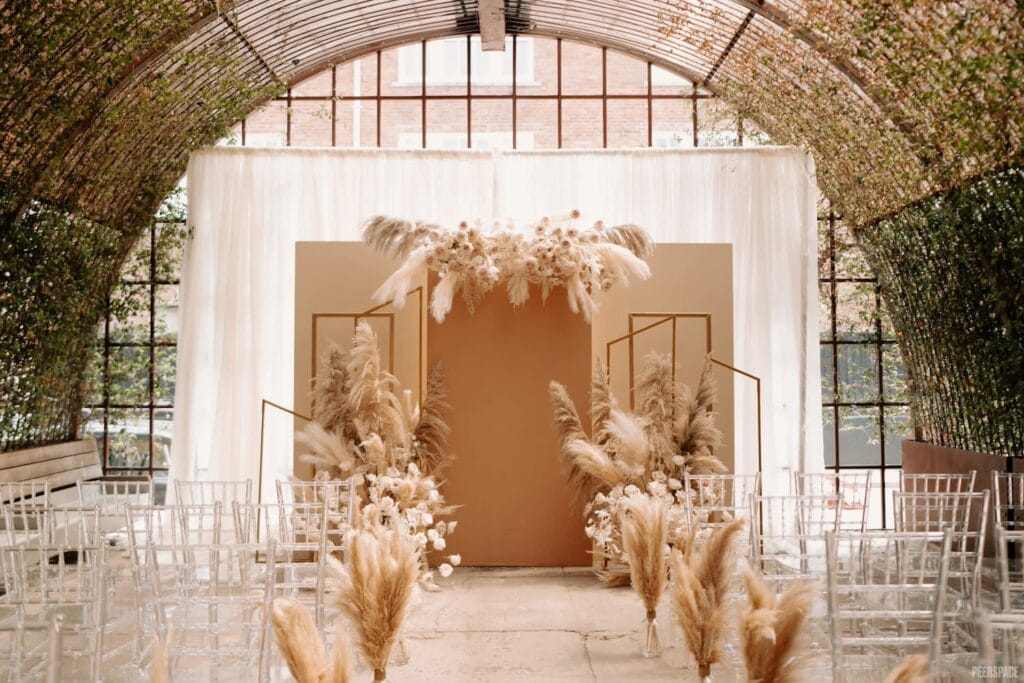 An altar decorate in feathers sits inside an industrial, curved room