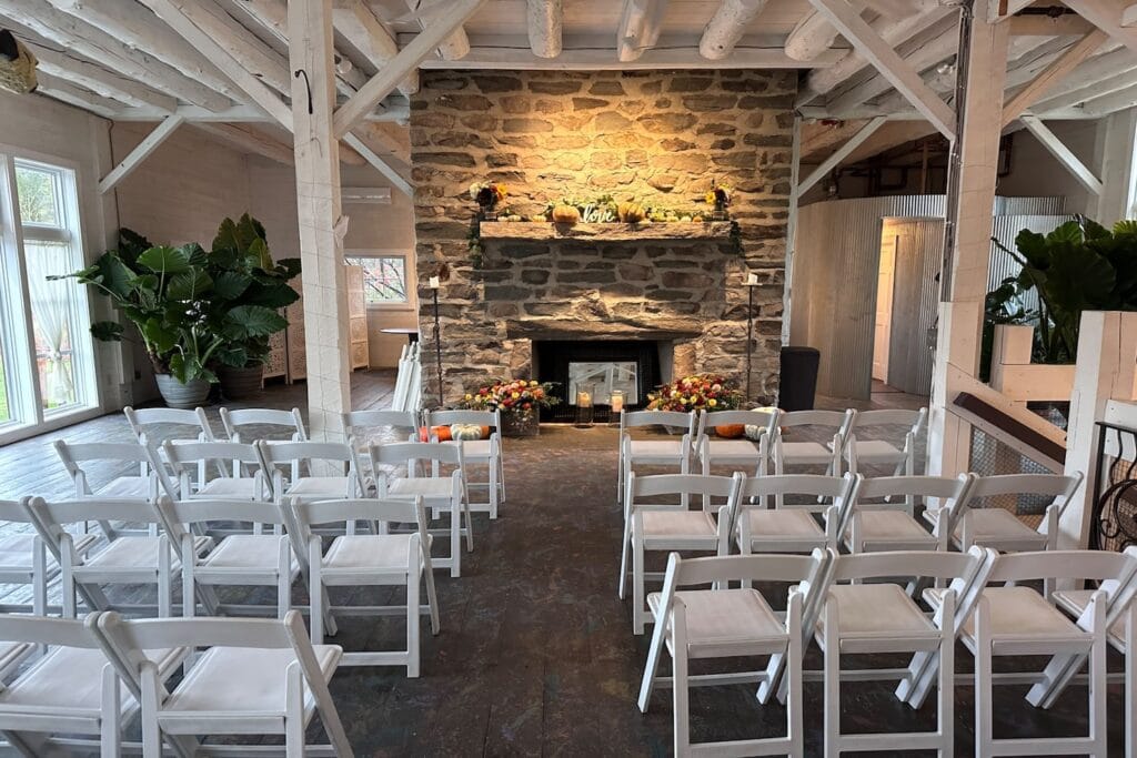 Intimate wedding ceremony set up by stone fireplace in a barn-like building