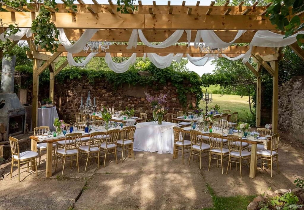 Simply decorated tables sit under a pergola