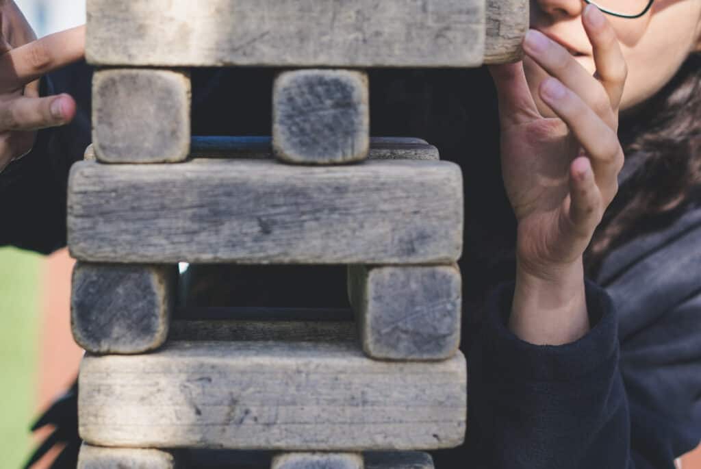 woman playing jumbo jenga on table