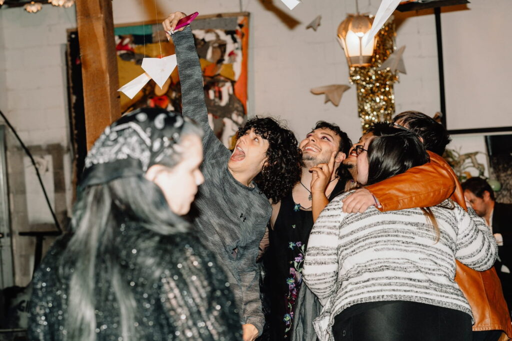 A joyful group poses for a selfie with arms draped around each other in a party space in Nashville