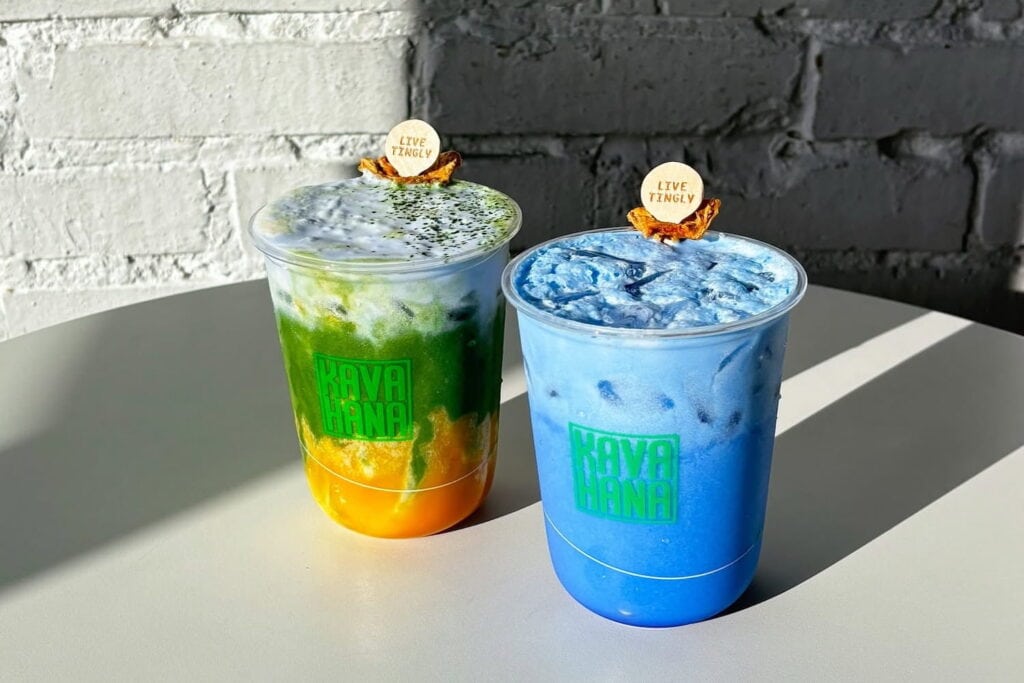 Colorful drinks in plastic cups sitting on a white table in the sunshine