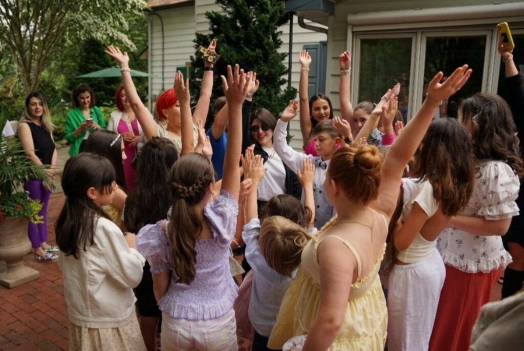 group of kids raising their hands