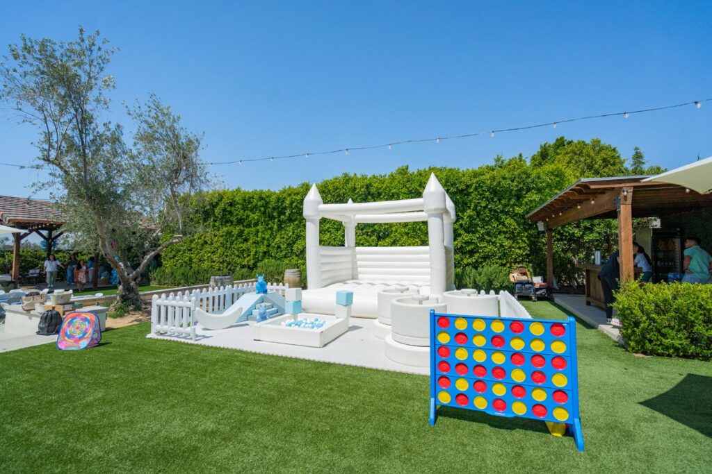 backyard with white bounce house and jumbo connect 4