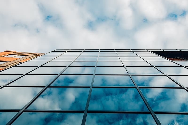 windows of building reflecting sky