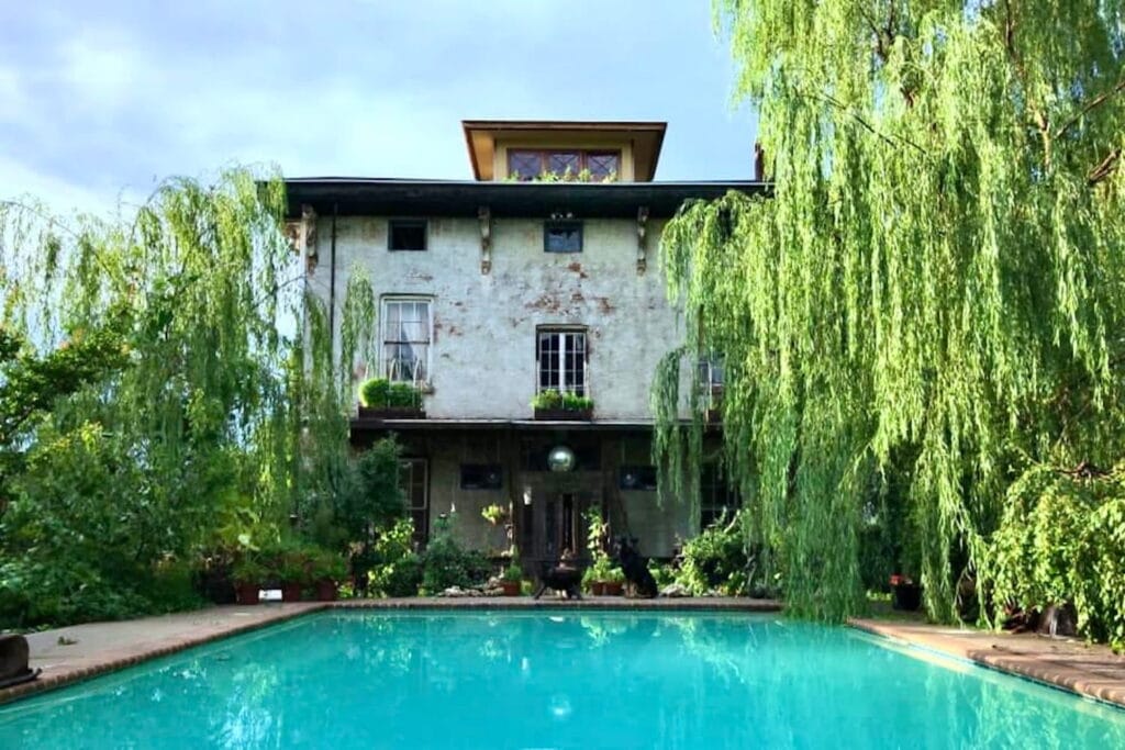 Unique brick home with pool surrounded by weeping willows