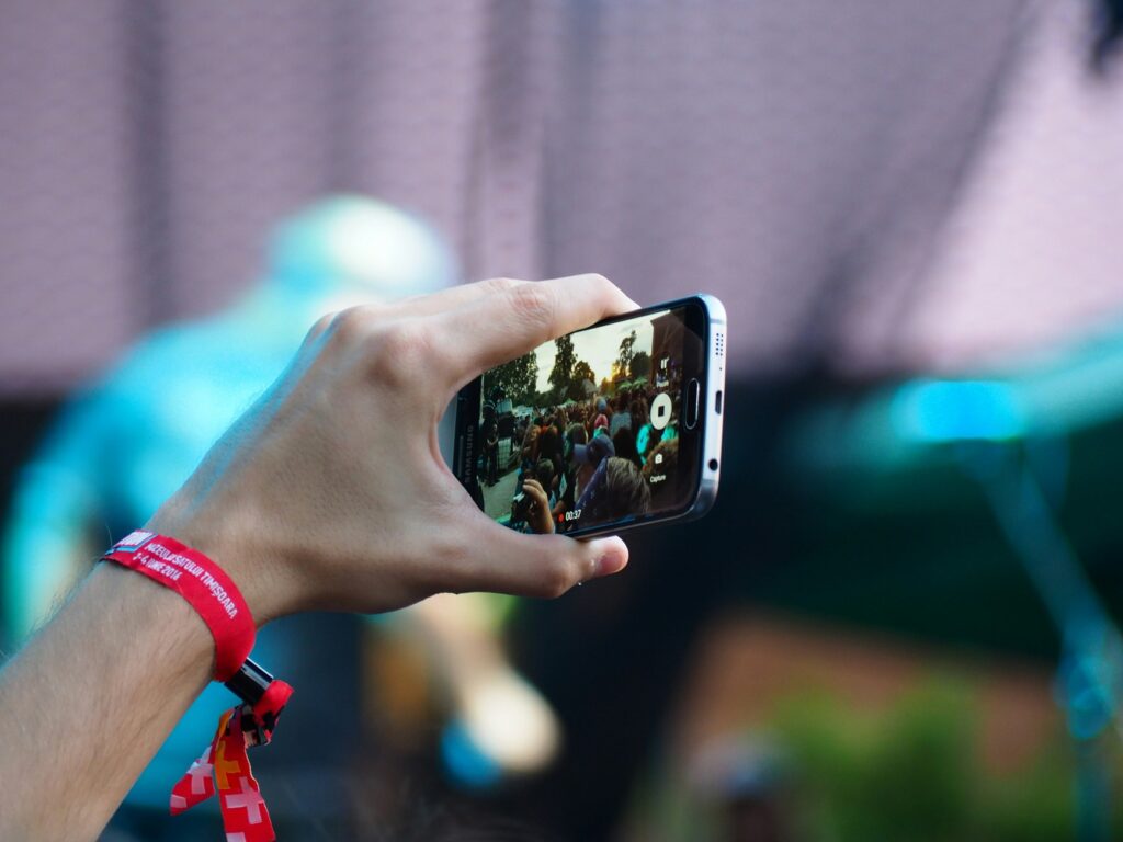 person-with-wristband-at-music-festival-holding-phone