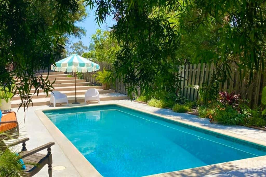 Sun-bathed home with pool, lush gardens, three-story windows