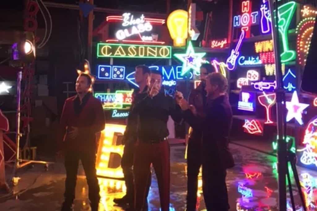 a group of men standing in front of neon signs