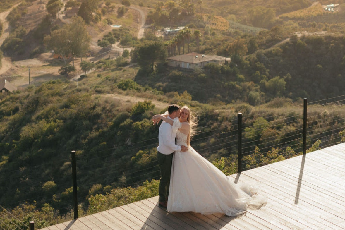 Couple embracing on scenic California overlook with valley landscape