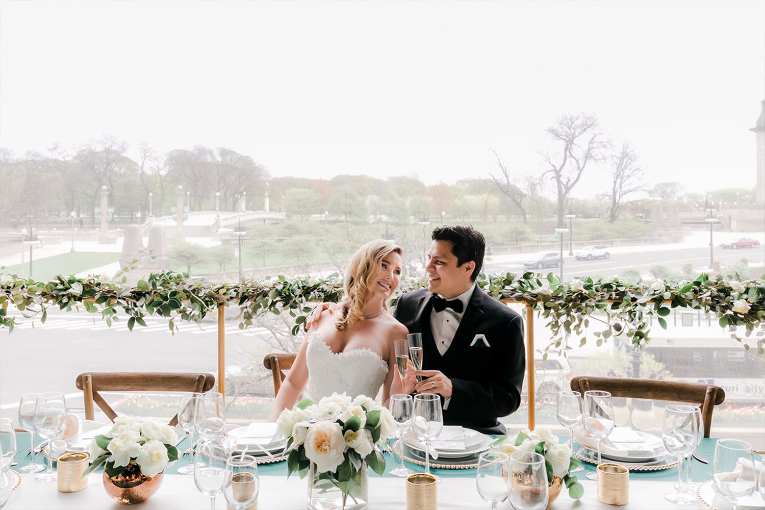 Dallas couple at elegant reception table with refined florals and champagne