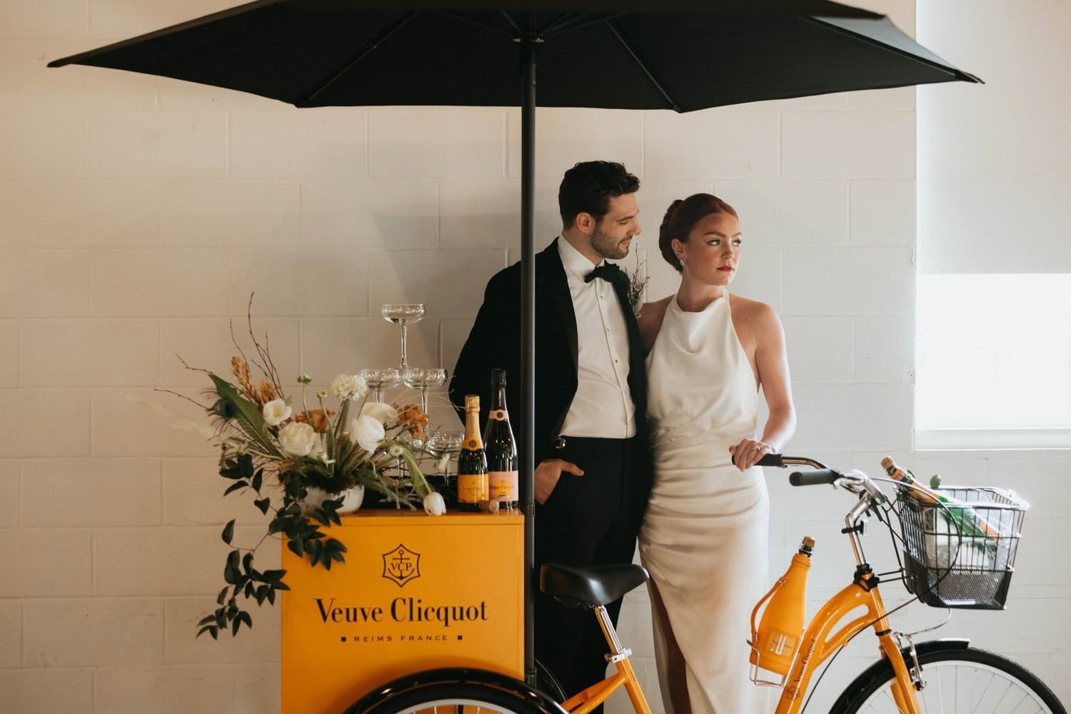 Stylish couple with Veuve Clicquot champagne cart at Dallas luxury wedding