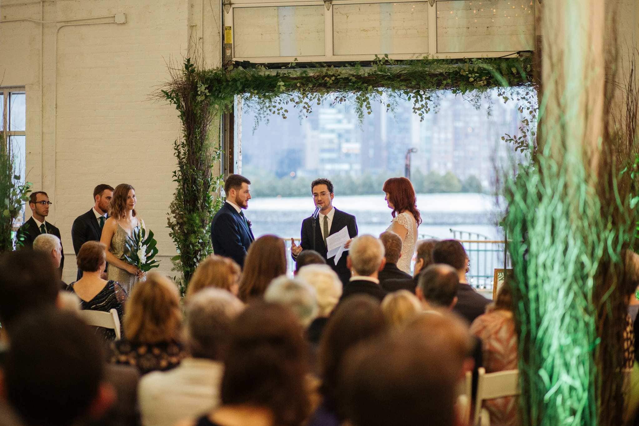 Upscale New York wedding ceremony with waterfront cityscape and greenery