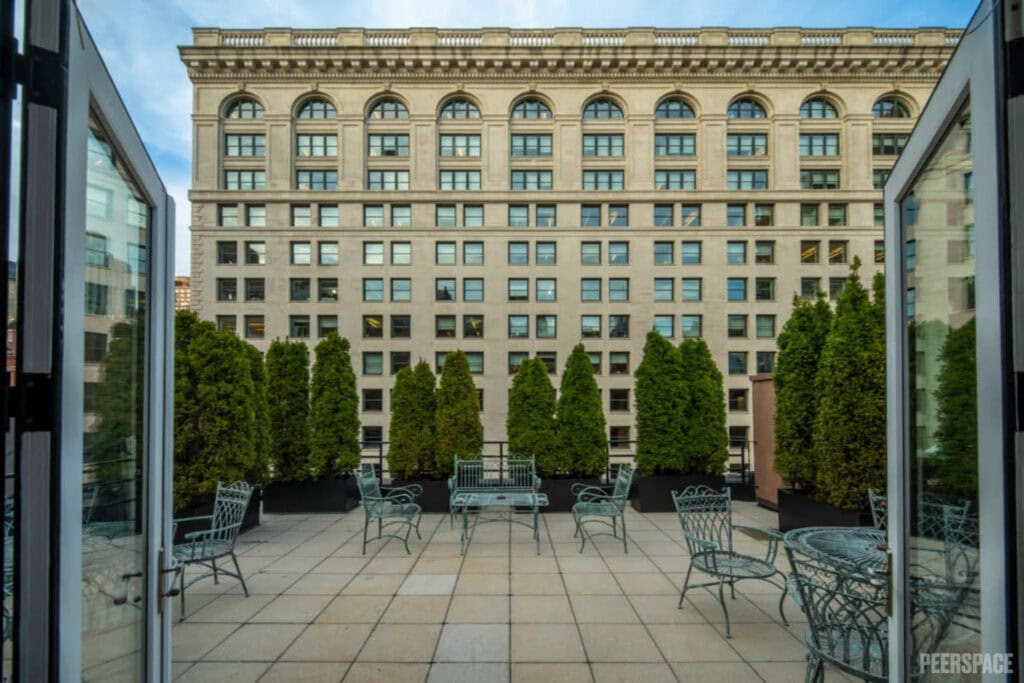 Evergreen trees border a rooftop terrace in the city