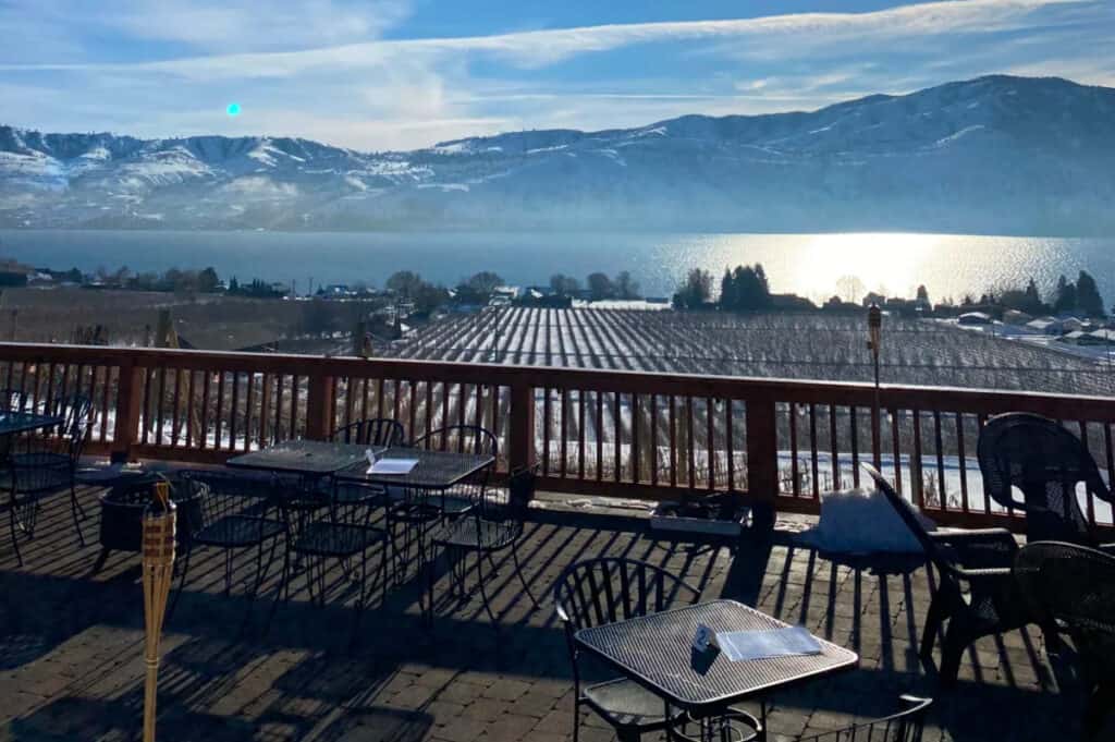 a winery overlooking a vineyard, a lake, and mountains