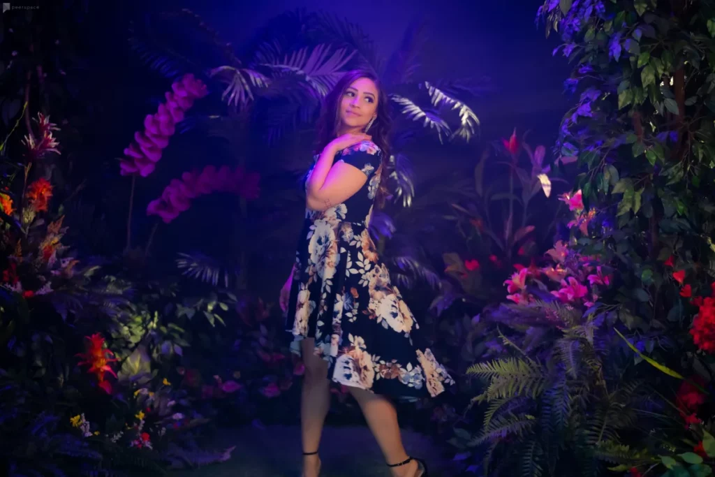 a woman standing in front of a jungle set