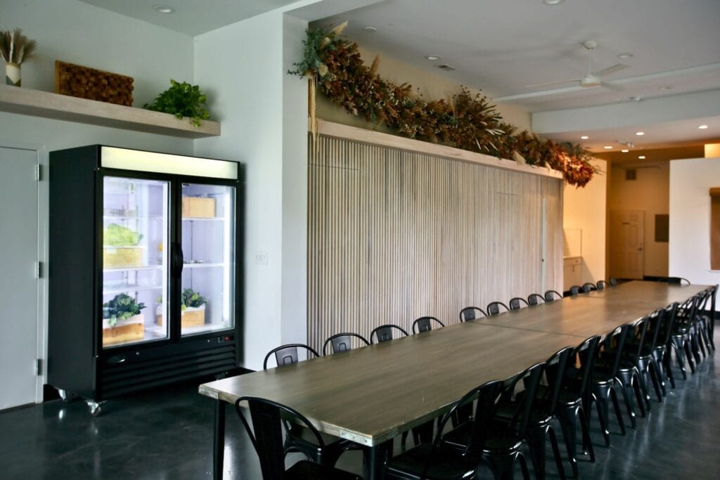 A modern meeting space with a wood-accented wall and a long conference table with black metal chairs