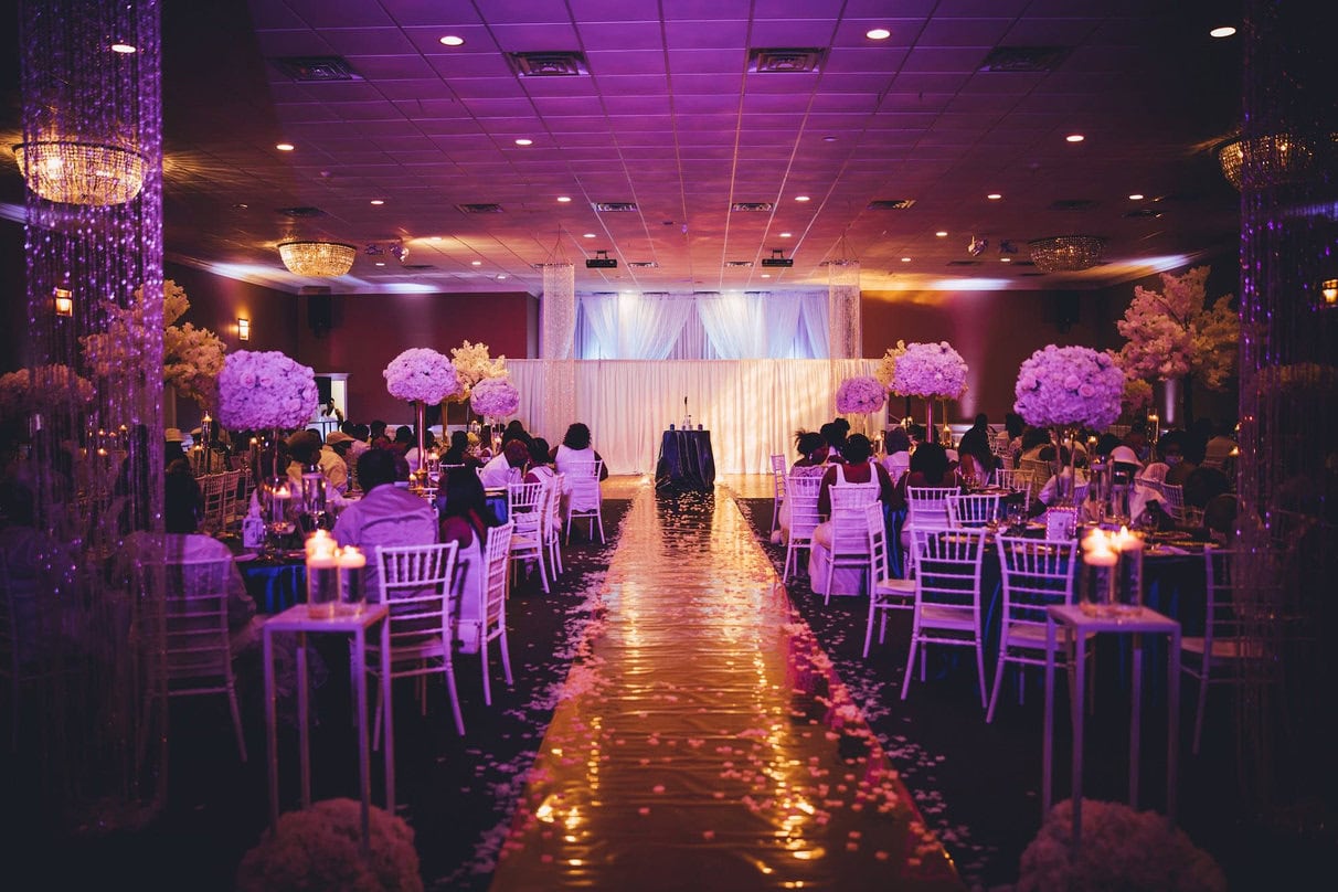 Houston Nigerian wedding planner arranging floral centerpieces for a reception