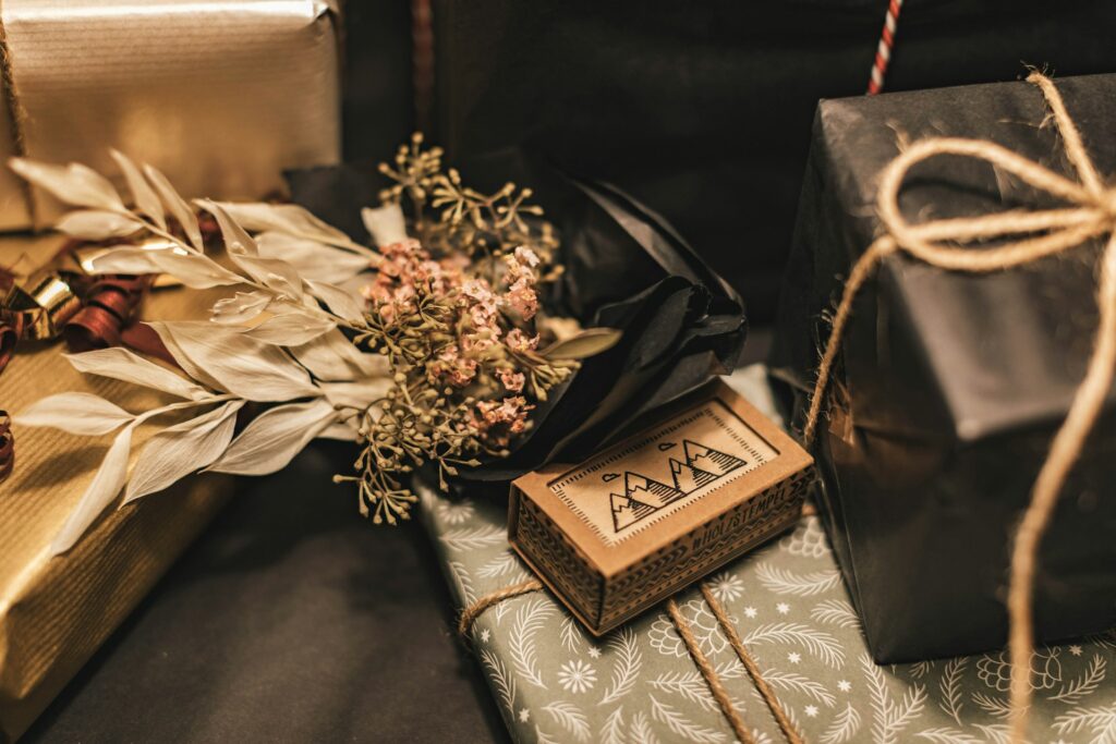 Wrapped Friendsgiving party favors including matchbook and florals arranged on a table