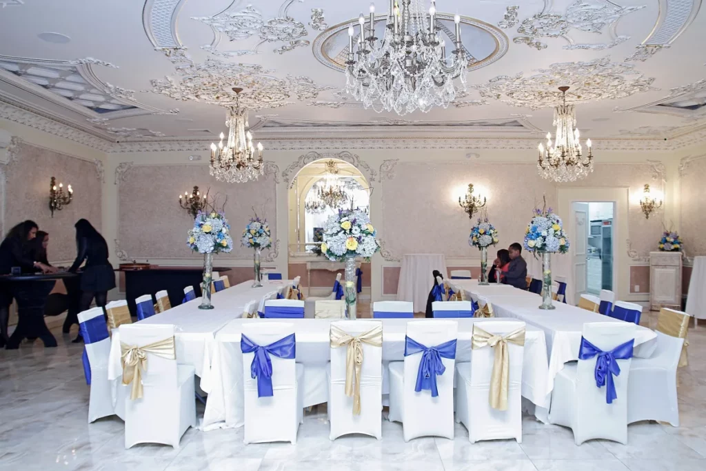 a luxurious banquet hall with tables and chandeliers