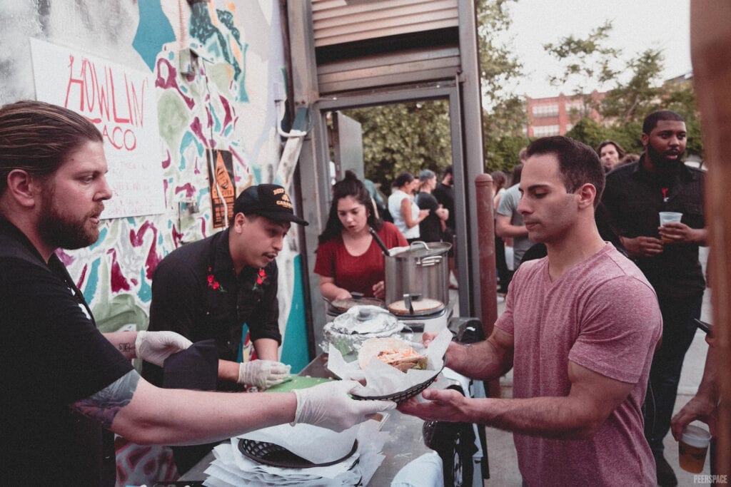 Partygoers in line at food vendor of outdoor party in NYC