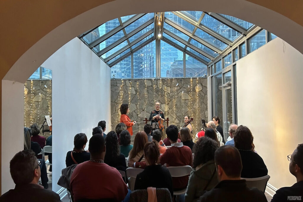 A small band performs in a NYC greenhouse space