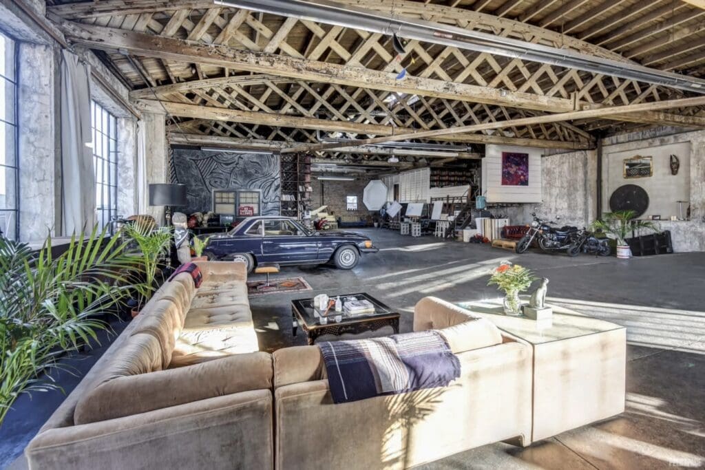Quintessential NYC loft space features cars and motorcycles in open party space