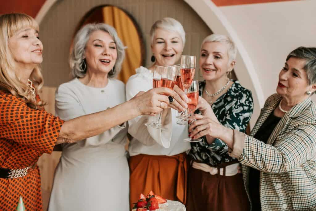 older elegant women clinking drinks