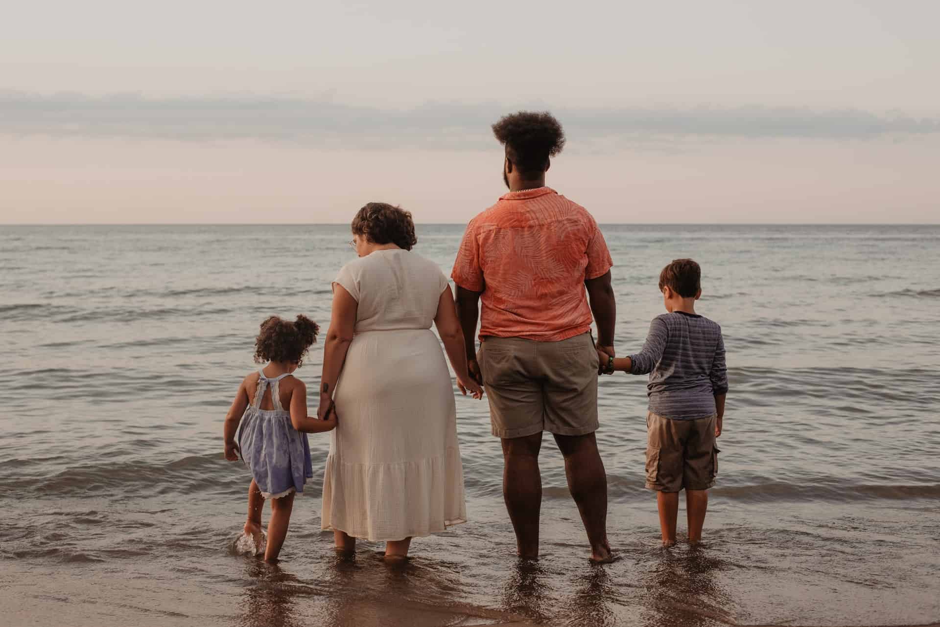 family standing on shoreline
