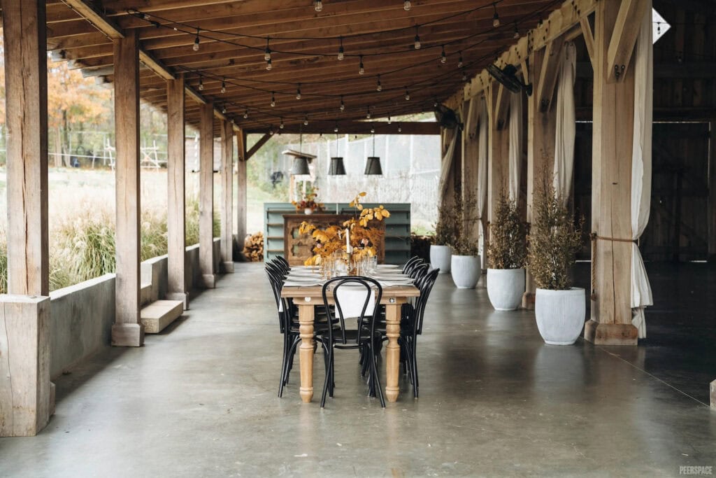 A dining table is set up outside on a rustic outdoor patio